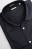 Close-up of a navy blue shirt with collar and buttons on a light gray background